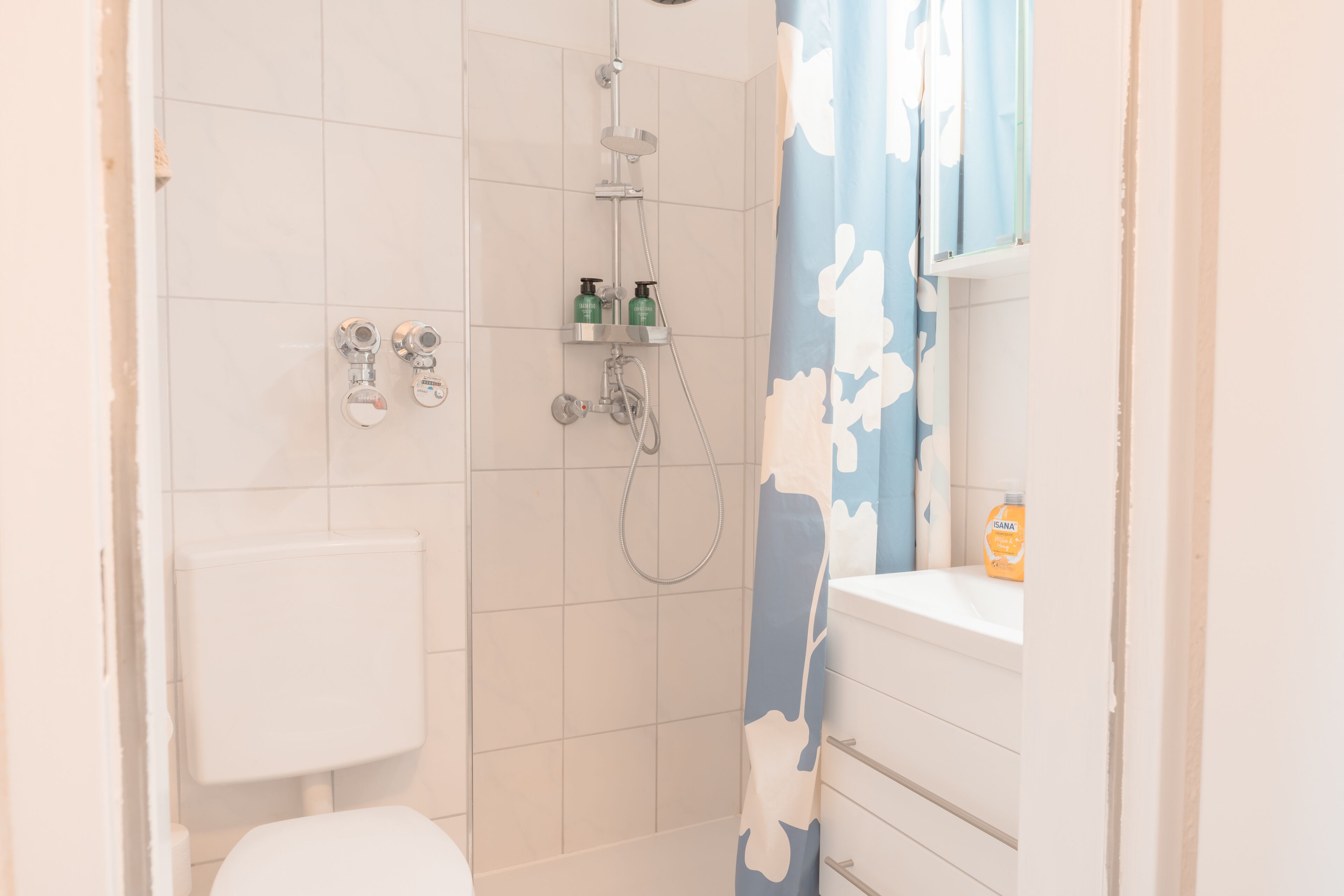 Ein Badezimmer mit Dusche, Toilette und Waschbecken.