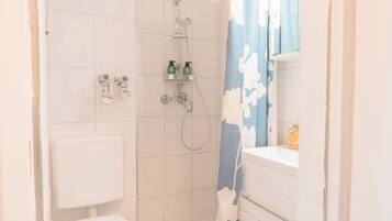 Ein Badezimmer mit Dusche, Toilette und Waschbecken.