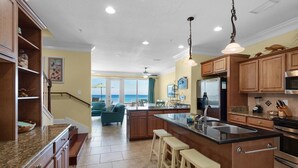 Una cocina amplia con una isla grande, armarios de madera y vistas al exterior.