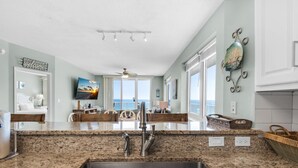 Cucina con piani di lavoro in granito, rubinetti in acciaio inossidabile e un'ampia finestra vista mare.