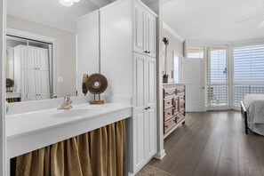 Une chambre avec un grand lit, une commode et un dressing.