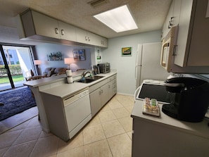 Eine Küche mit Kochinsel, Mikrowelle, Kaffeemaschine und Kühlschrank.