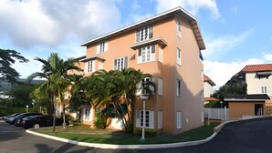 A multi-story building with a flat roof, large windows, and a parking lot with cars. - Secluded Ravinia Gem in Kingston  (Kingston)