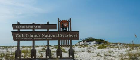 En träskylt med texten ”Santa Rosa-området” och ”Gulf Islands National Seashore”, som visar var parkens ingång finns.