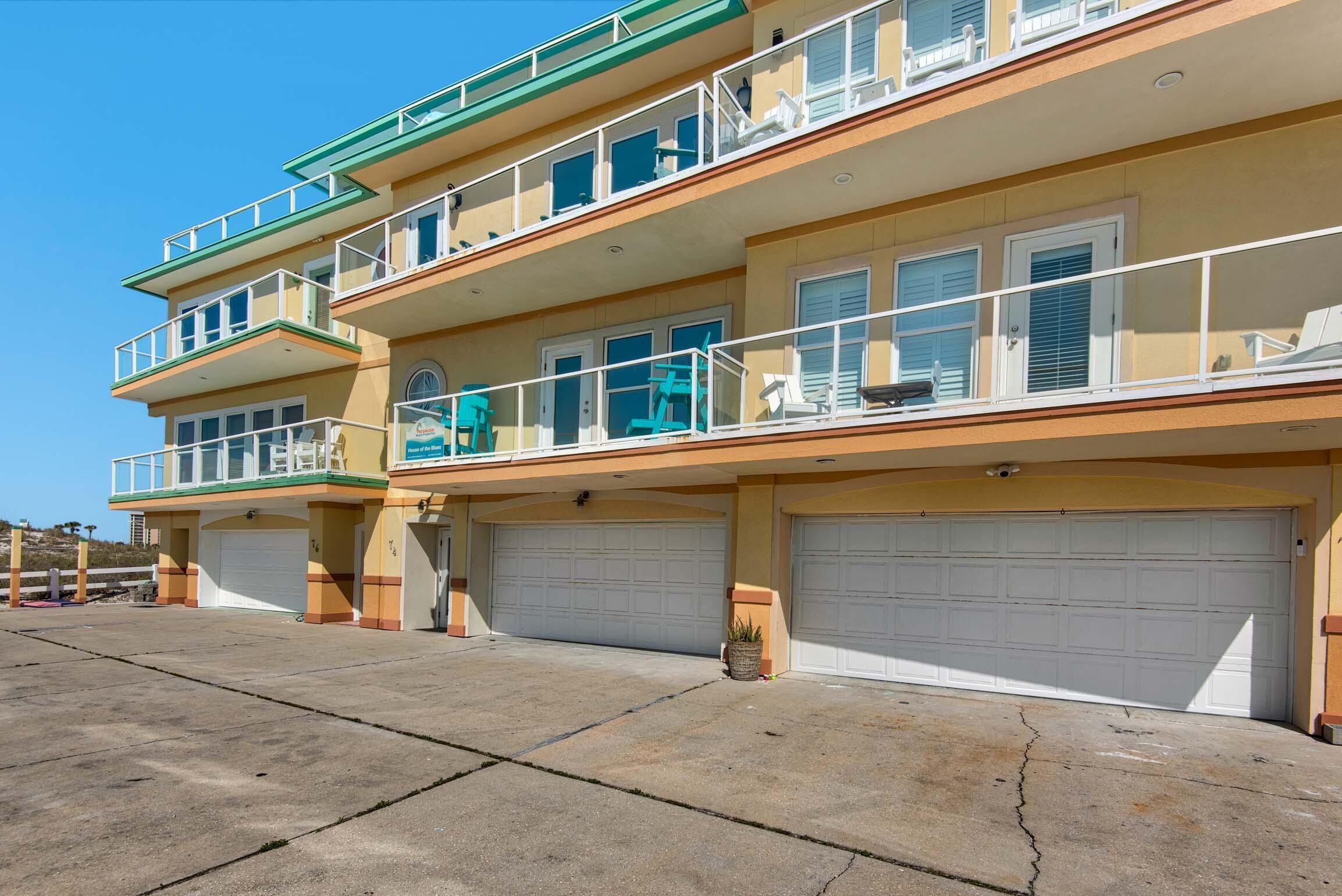 A multi-story residential building with balconies, a garage, and a clear view of the surrounding area.