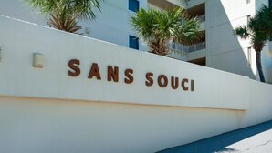 A white wall with the text "SANS SOUCI" in brown letters. - Sans Souci Unit 209 (Pensacola Beach)