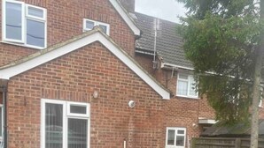 A brick house with a patio area featuring a grey sectional sofa and a dining table. - Flat 1,1 bedroom flat sleeps 4 in Abingdon Oxfordshire (Abingdon)