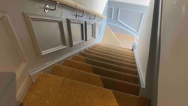 A staircase with carpeted steps leading to a landing with a white door. - Flat 1,1 bedroom flat sleeps 4 in Abingdon Oxfordshire (Abingdon)