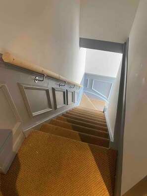 A staircase with carpeted steps leading to a landing with a white door. - Flat 1,1 bedroom flat sleeps 4 in Abingdon Oxfordshire (Abingdon)