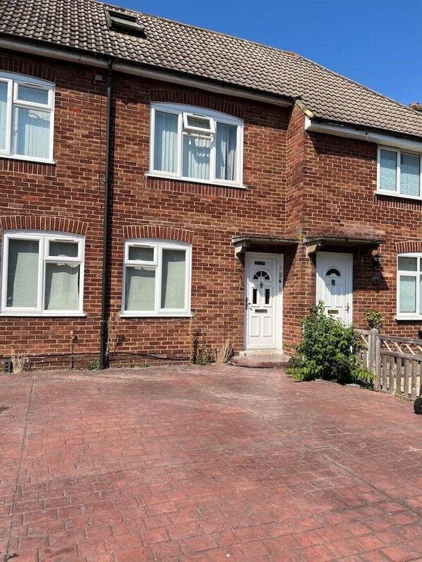 A two-story brick house with a front entrance, two windows on the ground floor, and a tiled roof. - Flat 1,1 bedroom flat sleeps 4 in Abingdon Oxfordshire (Abingdon)