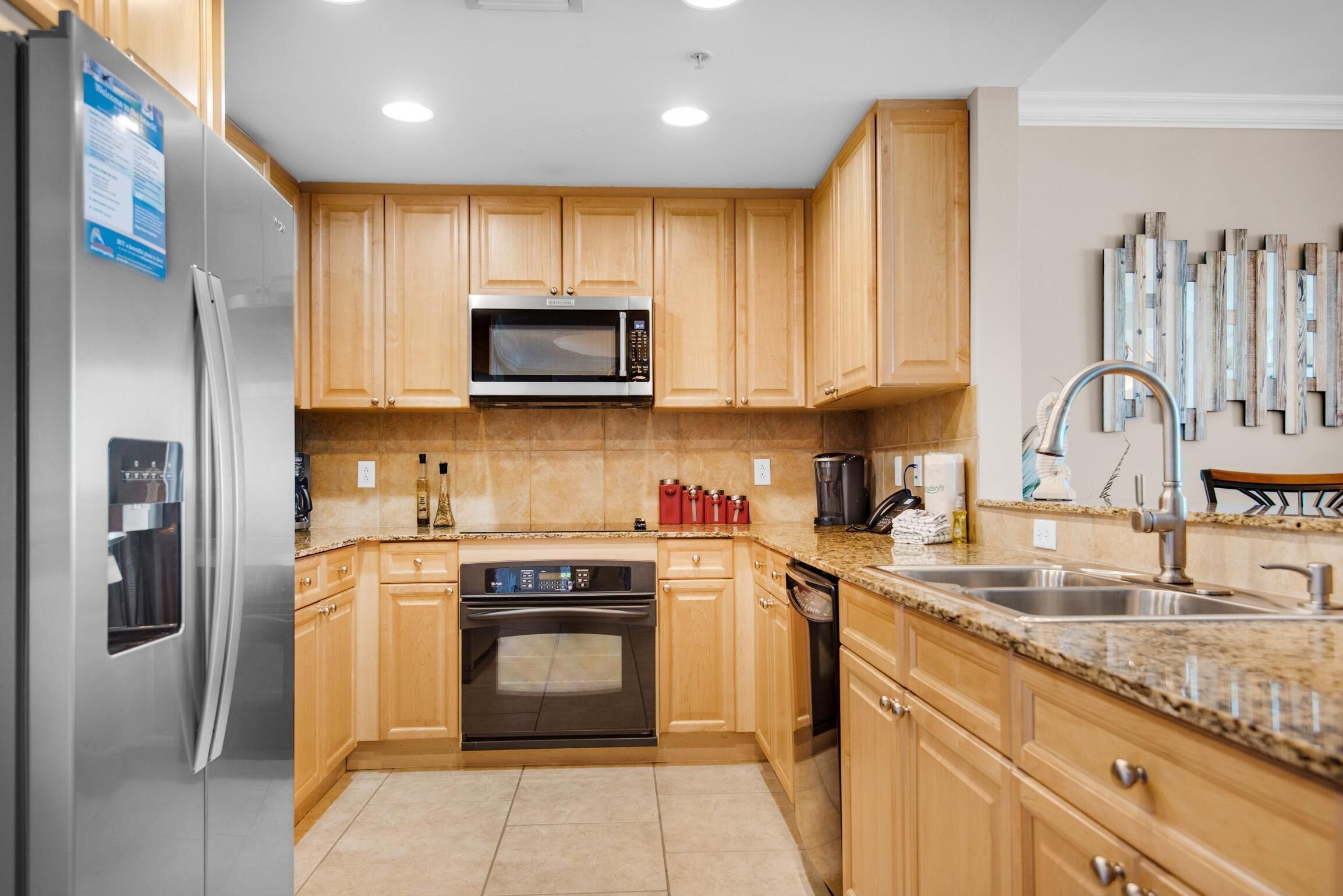 A modern kitchen with wooden cabinets, stainless steel appliances, and granite countertops.