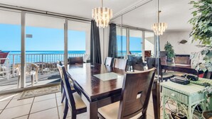 Un espace repas avec vue sur l’océan, un balcon avec des sièges d’extérieur et une grande fenêtre.