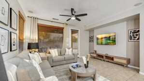 A modern living room with a sofa, coffee table, and artwork on the wall.