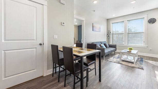 A dining area with a table and chairs, a sofa, and a coffee table.