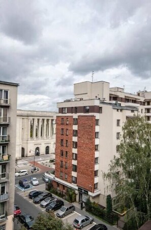 Stylish urban residence with a brick and plaster facade, featuring balconies and a parking area.