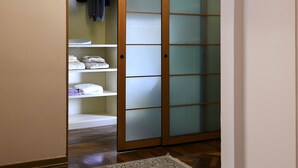Ein begehbarer Kleiderschrank mit Schiebetüren, Regalen und Ablagefläche zum Aufhängen.
