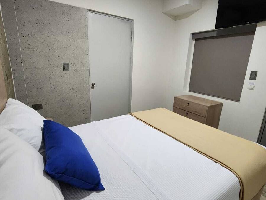 Une chambre à coucher comprenant un lit, une armoire, une table de chevet et un appareil de climatisation.