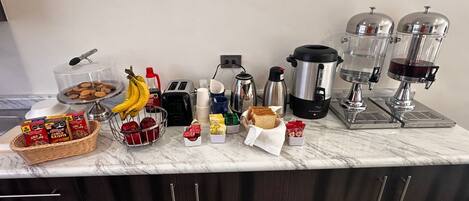 A kitchen counter with various items including a coffee maker, toaster, and food containers.
