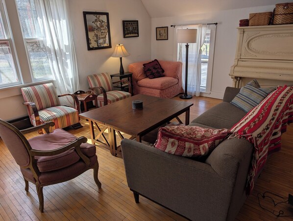 A cozy living room with a sofa, armchairs, a coffee table, and a lamp.