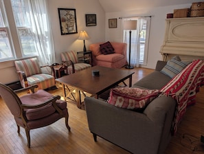 A cozy living room with a sofa, armchairs, a coffee table, and a lamp.