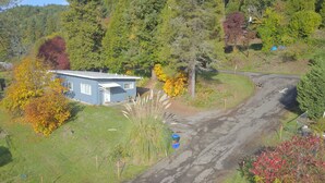 Una casa amb façana blava, un petit porxo i un camí de terra.