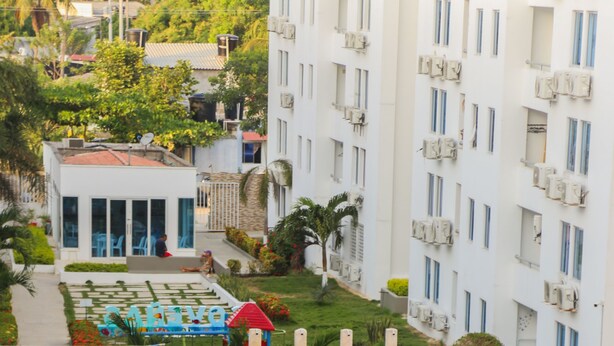 Una piscina con sillas de descanso y un pequeño jardín.