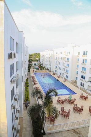 A hotel with a swimming pool, outdoor seating, and multiple balconies. - Atardecer by Olamar Living (Coveñas)