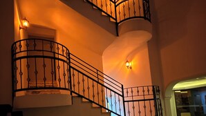 A multi-level interior with a curved staircase, a seating area, and a view of the adjacent room. - Casa Cleo Suite (Alanya)