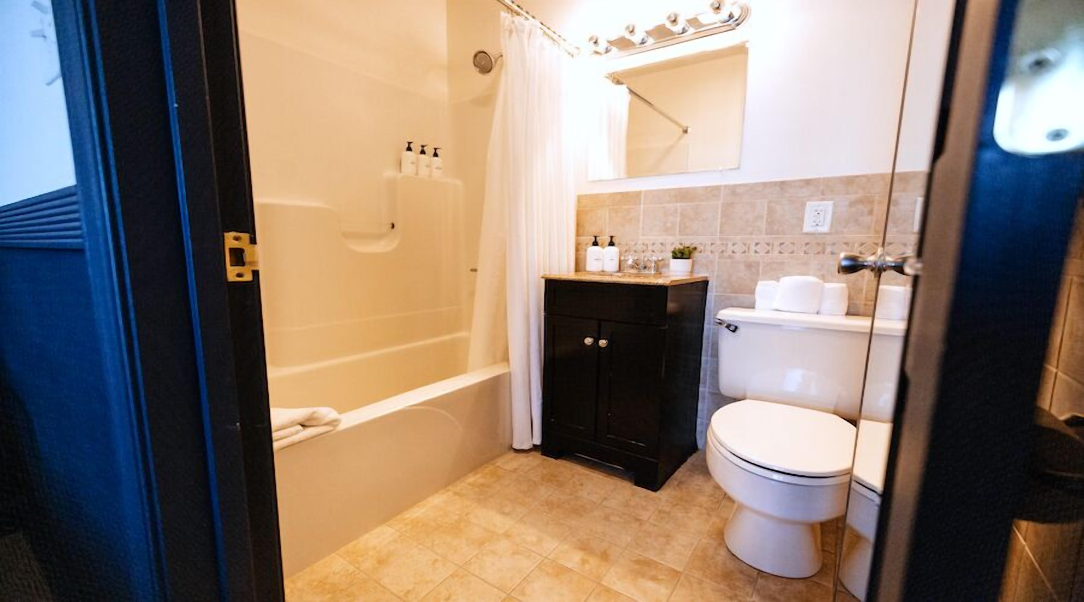Un baño con bañera, inodoro y lavamanos.