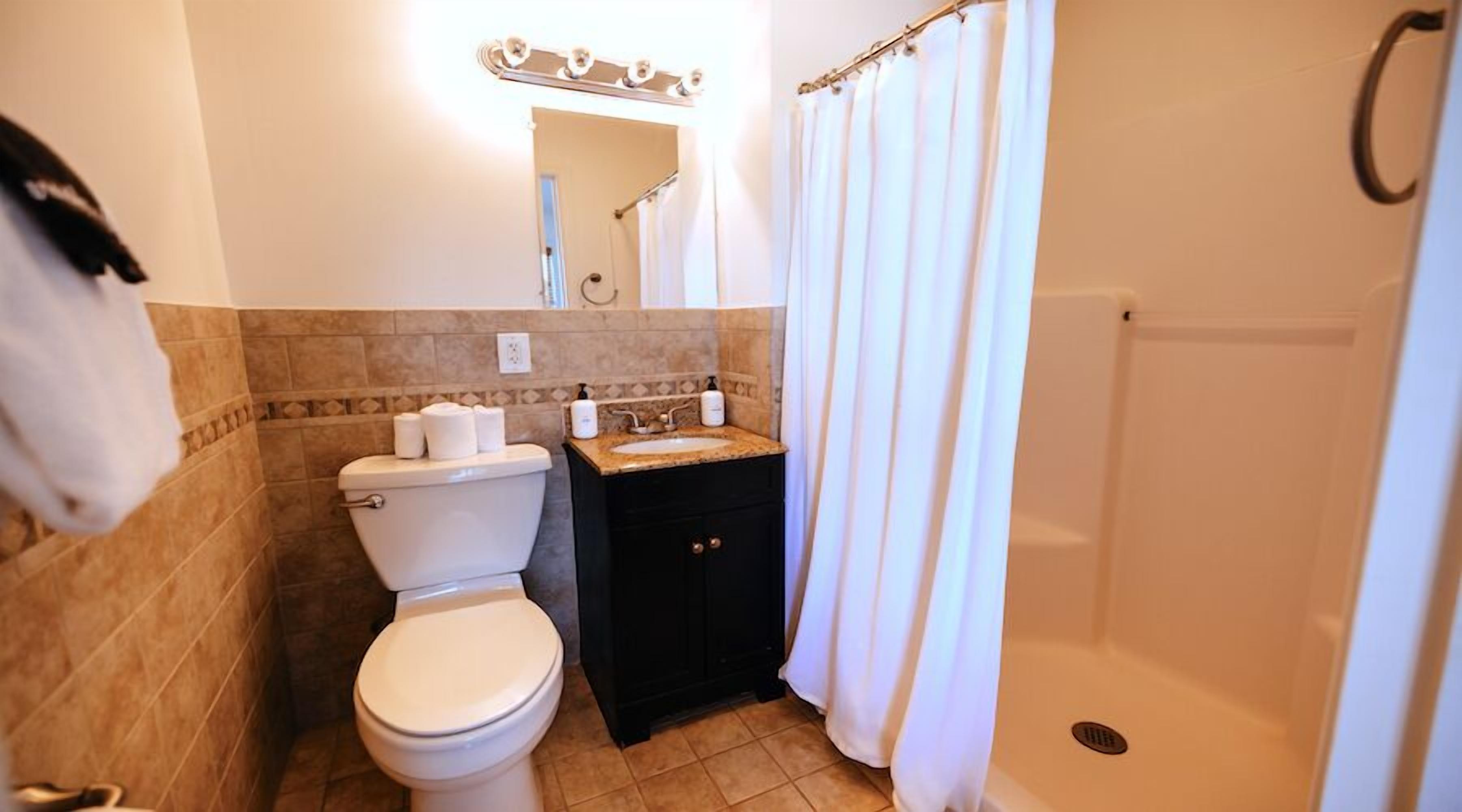 A bathroom with a toilet, sink, and shower.