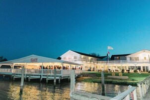 A waterfront hotel with a covered dock and a large building with multiple balconies.