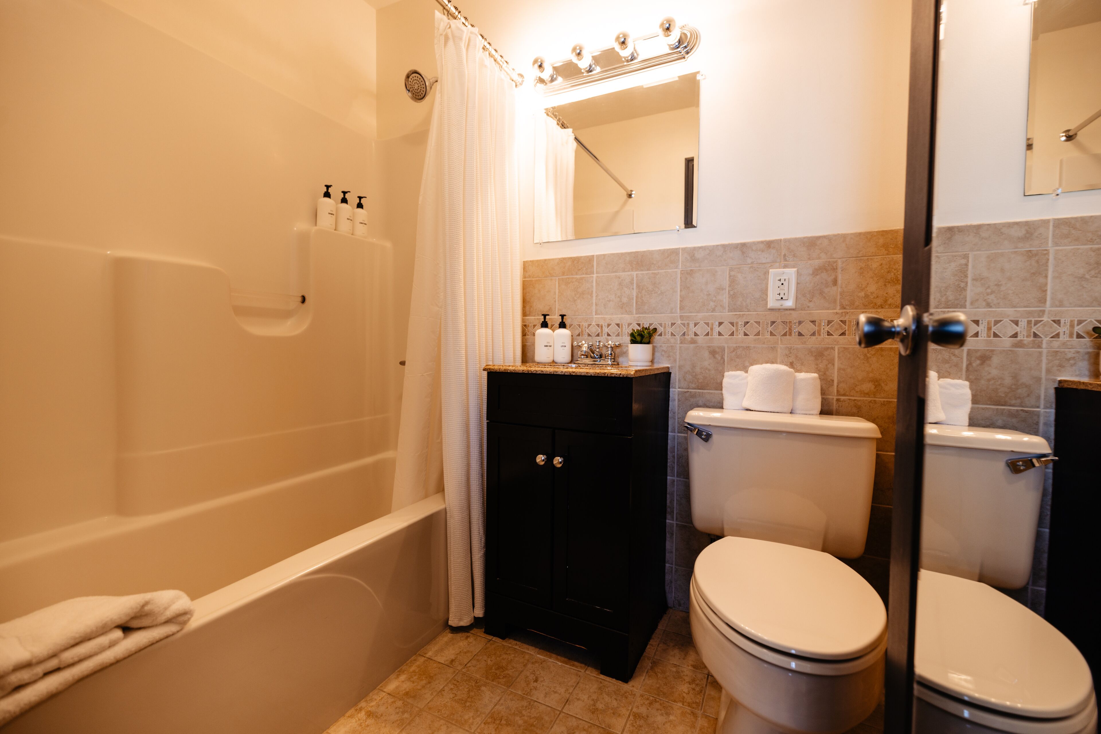 Un baño con bañera, inodoro y tocador.