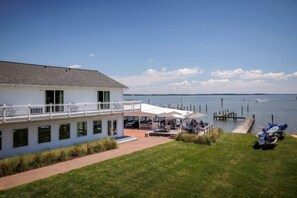 A waterfront property with a covered patio, a dock, and a boat. - Wylder Tilghman Island (Tilghman)