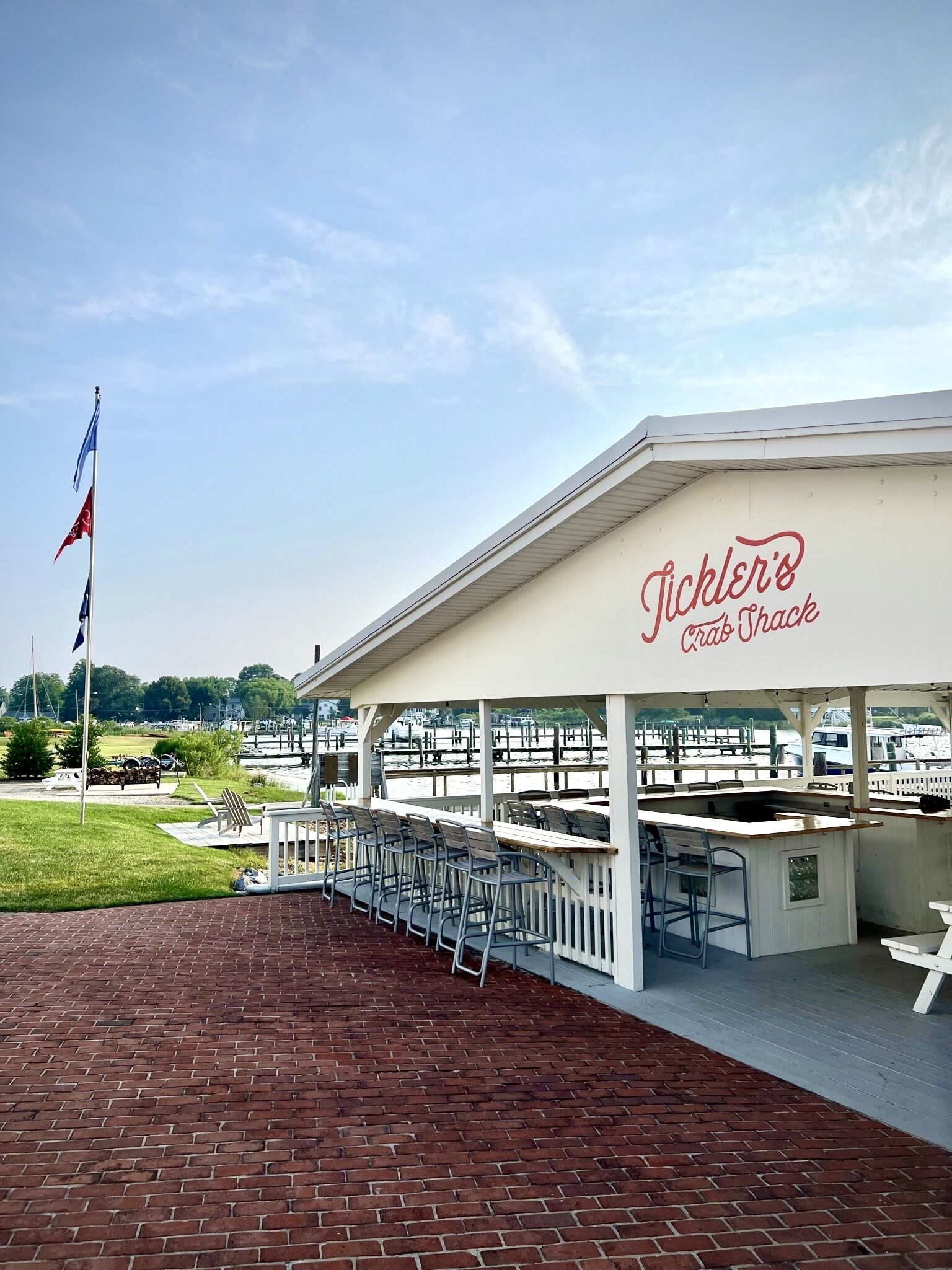 Un restaurant situé au bord de l’eau, appelé « Pickler’s Crab Shack », qui dispose d’une terrasse et offre une vue sur le port de plaisance.