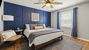 A bedroom with a bed, a chair, a bedside table, a ceiling fan, and a window with curtains. - Welcome Home! 10 mins to the Horse Park, Bourbon Trail & We're Pet Friendly (Georgetown)