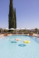Una piscina al aire libre, camas de piscina gratis, sombrillas