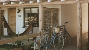 A wooden house with a tiled roof, a hammock, and two bicycles parked outside. - River Lodge Paso - 21 & Over Pool (Paso Robles)