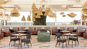 A restaurant with wicker hanging lights, cushioned seating, and a patterned floor. - River Lodge Paso - 21 & Over Pool (Paso Robles)