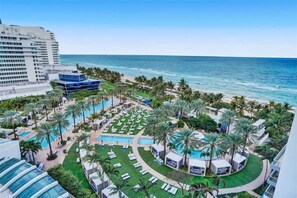A resort with multiple swimming pools, palm trees, and a view of the ocean. - FONTAINEBLEAU MIAMI SORRENTO oceanfront 1 bedroom (Miami Beach)