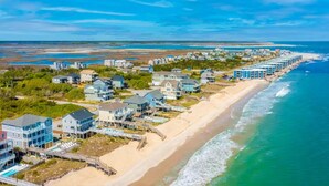 A coastal residential area with beachfront properties, including houses and condos, and a sandy beach adjacent to the ocean. - Spacious Oceanfront | Sleeps 30!
 (North Topsail Beach)