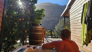 A man relaxing in a hot tub with a mountain view. -  Cabin with jacuzzi in its 800 meter private land with fruit trees.  (fataga)