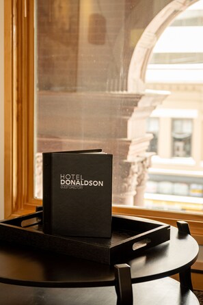 A black guest directory for the Hilton Hotel on a tray. - Hotel Donaldson (Fargo)