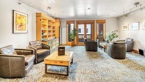 A spacious lobby with leather sofas, a wooden coffee table, and a bookshelf. - Hotel Donaldson (Fargo)