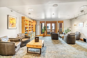 A spacious lobby with leather sofas, a wooden coffee table, and a bookshelf. - Hotel Donaldson (Fargo)