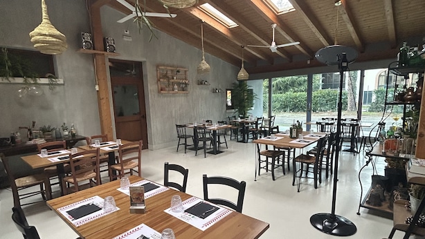 A spacious restaurant with wooden tables and chairs, ceiling fans, and large windows offering a view of the outdoors. - La Lista Rooms Venice CO Doge Veneziano (Mestre)