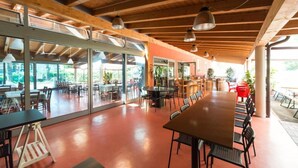 An indoor dining area with a long table and chairs, wooden ceiling beams, and large windows. - La Lista Rooms Venice CO Doge Veneziano (Mestre)