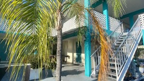 A building with a staircase, palm trees, and a clear blue sky. - Bposhtels Clearwater Tampa (Clearwater)
