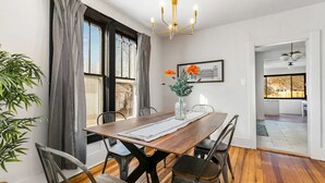 A dining area with a wooden table, metal chairs, a vase with flowers, and a framed picture on the wall. - Restored farmhouse in Old Town Loveland

 (Loveland)