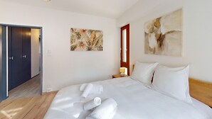 A hotel room with a bed, a nightstand, a lamp, and artwork on the walls. - Bail Mobilité - Finkwiller (Strasbourg)
