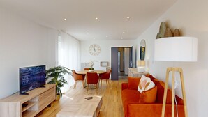 A modern living room with a wooden coffee table, red sofa, and a TV on a wooden stand. - Bail Mobilité - Finkwiller (Strasbourg)